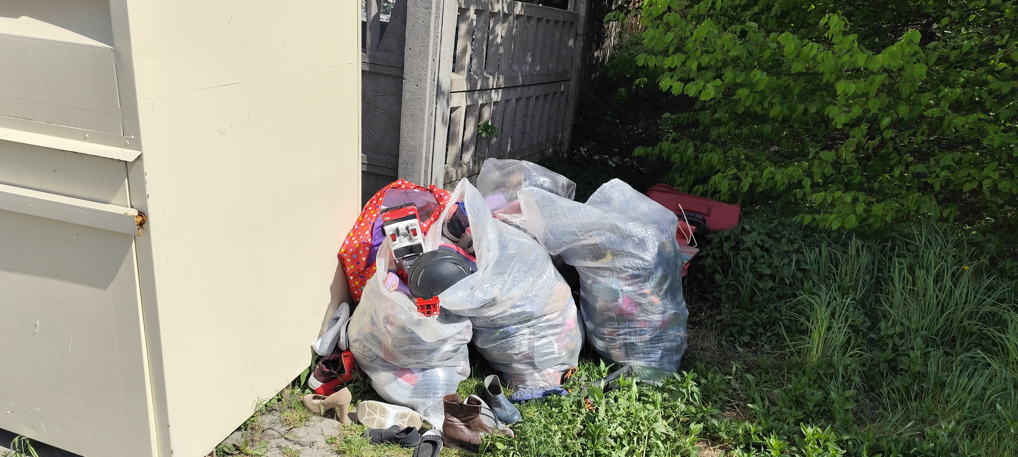 Kontener przy kt&oacute;rym ustawiono worki z ubraniami ujęcie 1